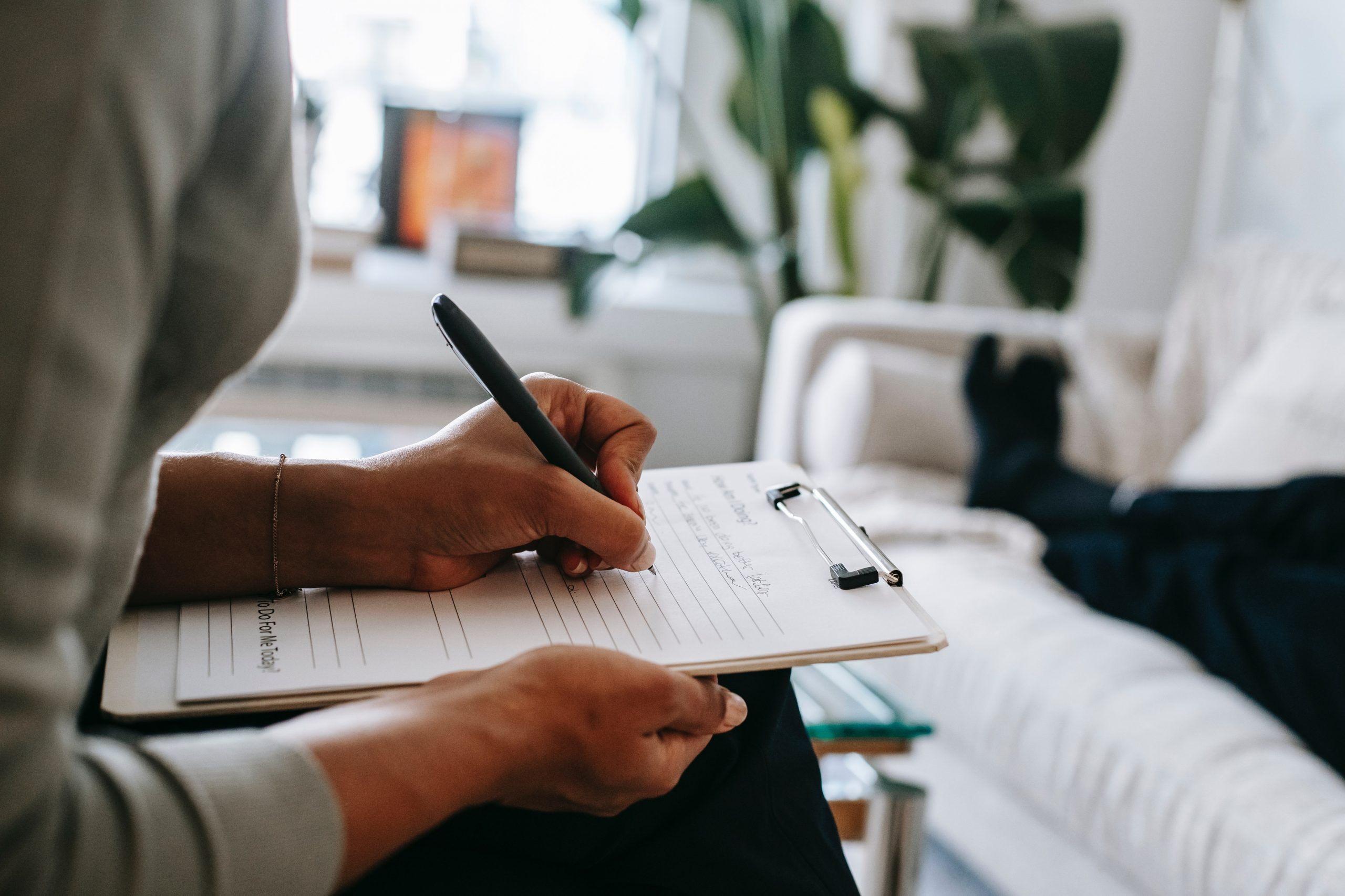 A close-up of hands taking notes in a calm consultation room